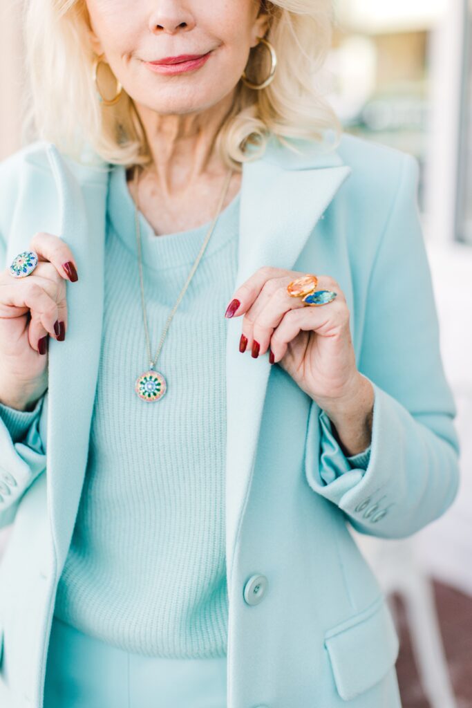 Woman wearing a seafoam overcoat with  cashmere sweater 