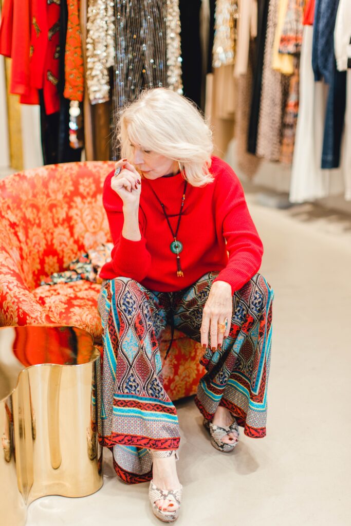 Woman wearing a red cashmere sweater and print palazzo pants 