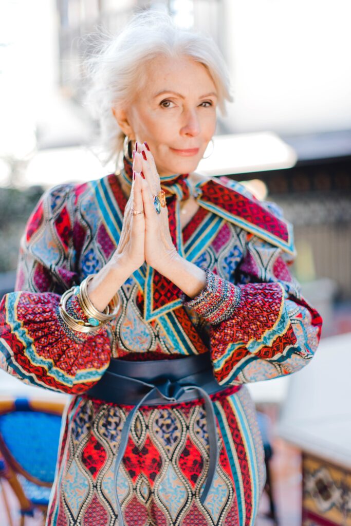 Woman wearing print palazzo pants and top with a leather wrap belt for the spring travel capsule wardrobe edit with Alice and Olivia