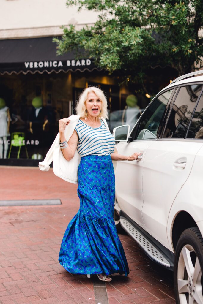 Woman wearing floral skirt and striped top with a white blazer