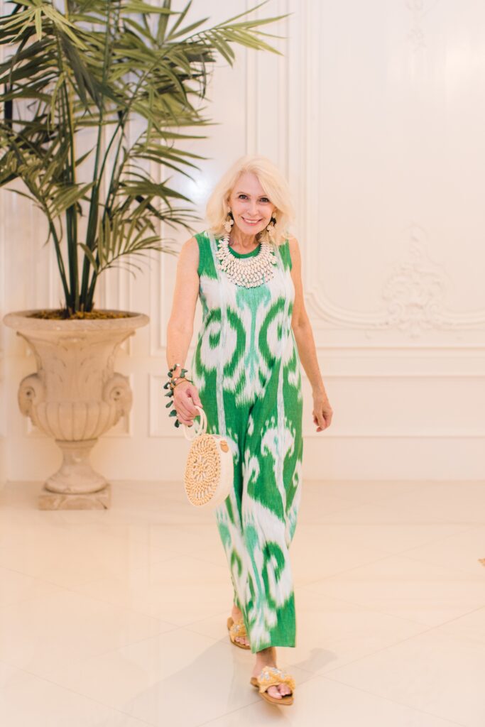 Style Beyond Age wearing modern green printed dress. bib necklace and beaded handbag