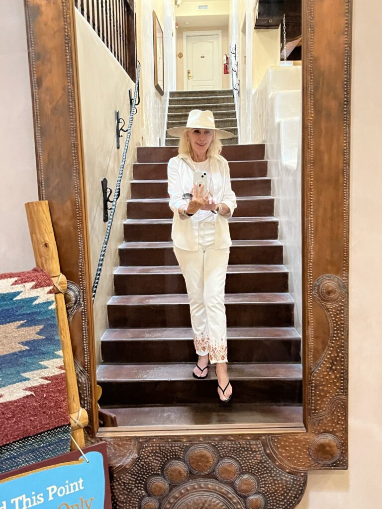 Style Beyond age taking picture on a staircase, in a mirror, wearing all white outfit