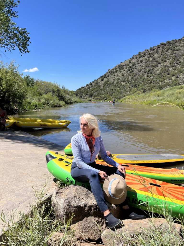 Style beyond age sitting on paddle board in front of Rio Grande River