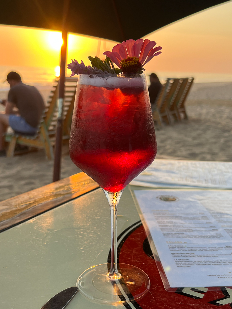 Red beverage at sunset on the beach