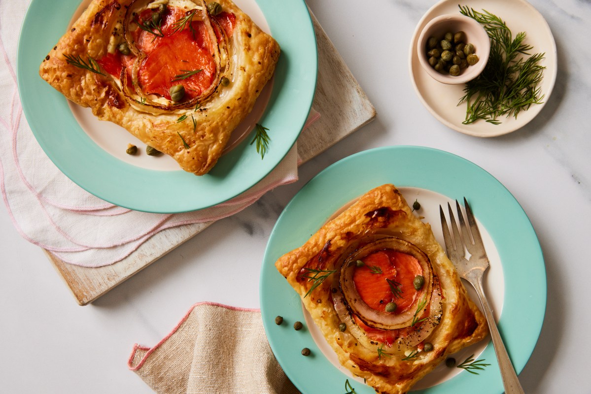 Golden salmon and cream cheese puff pastries topped with capers and fresh herbs.